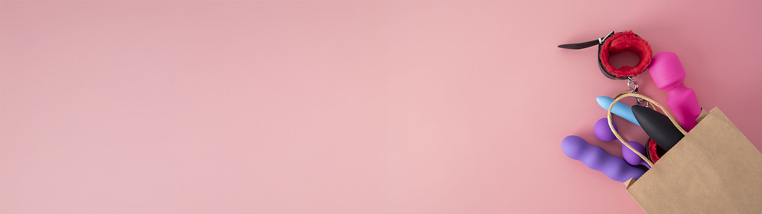 Colorful accessories including a hairbrush, hair tie, and small bag on a pink background