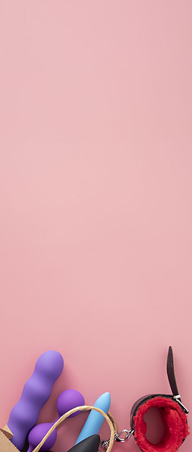 Assorted colorful sex toys on a pink background